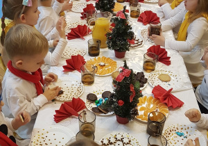 dzieci siedzą przy świątecznie nakrytym stole